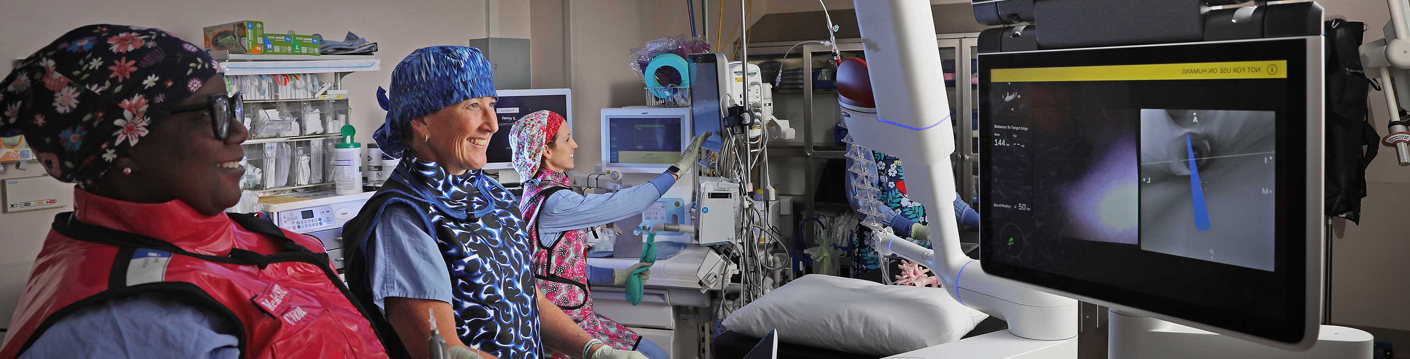 Smiling nurses reviewing scans in the cardiopulmonary department.