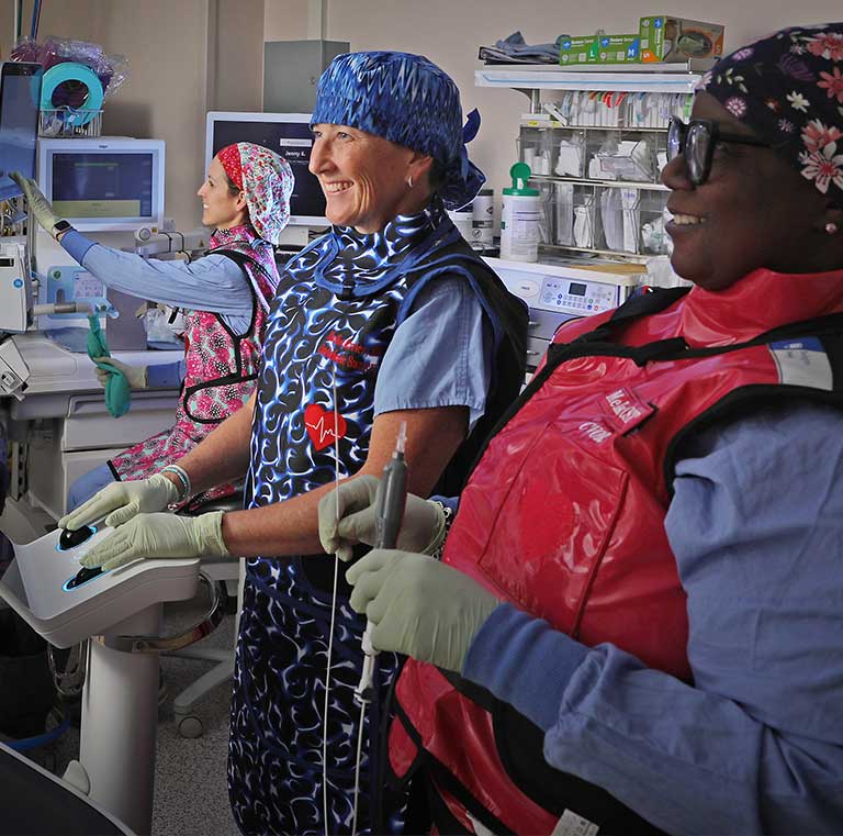 Smiling nurses reviewing scans in the cardiopulmonary department.