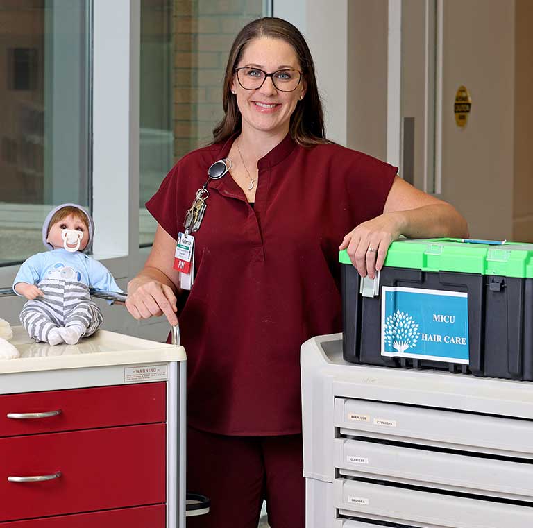 A smiling nurse with hospital supplies.