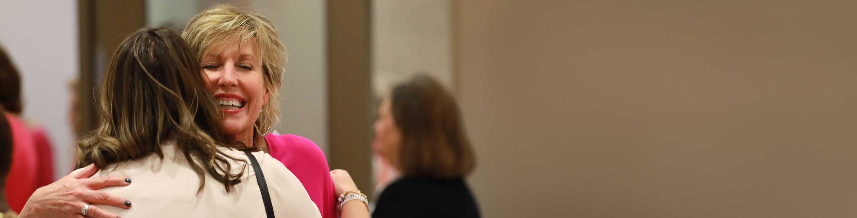 Two women smiling and hugging.